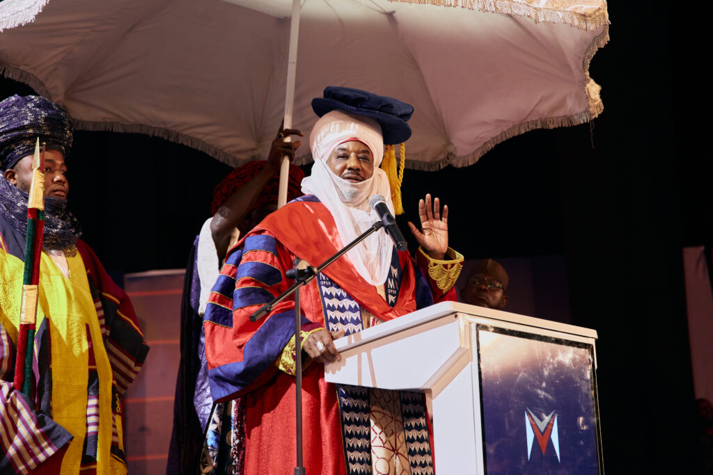 A medium long shot of His Highness Khalifa Muhammad Sanusi II giving his address.